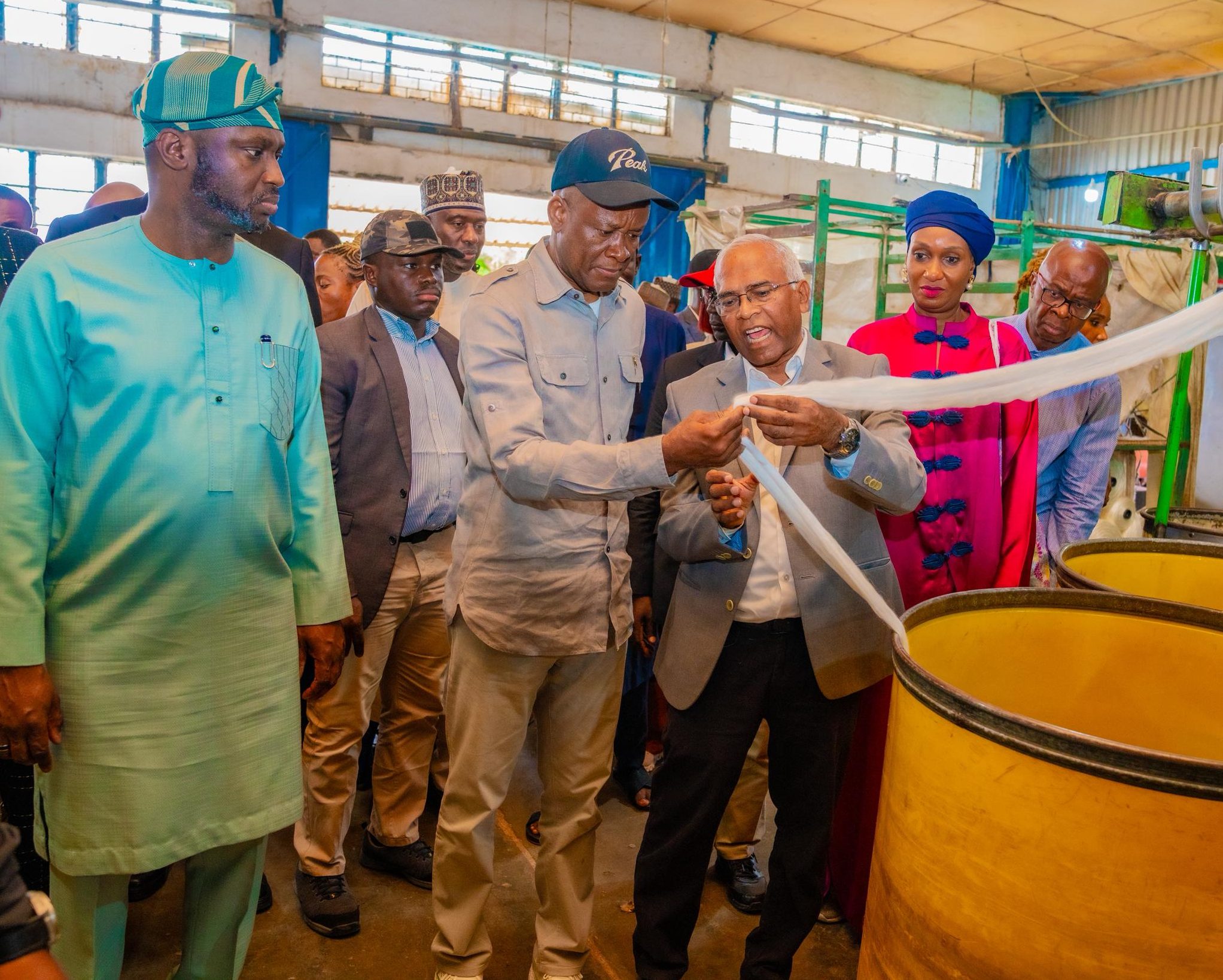 BOI MD Dr. Olasupo Olusi and Minister of State for Industry, Senator John Owan Enoh inspecting locally produced textile fabric at Chellco Industries in Kaduna during a site tour focused on reviving Nigeria’s Cotton, Textile, and Garment sector.